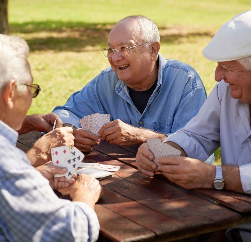 Male residents playing cards outside