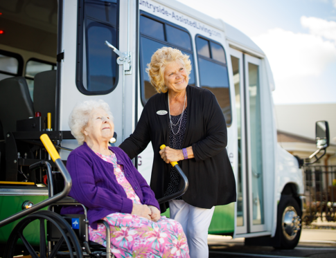 Transportation Woman being automated down from the bus with a staff worker helping