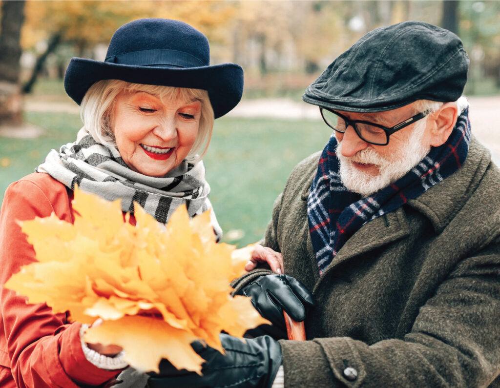 Senior man and woman collecting a bouquet of fall leaves